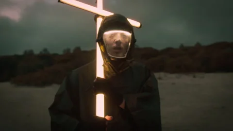 Post apocalyptic scene of a man carrying a neon cross Stock Footage 327066218