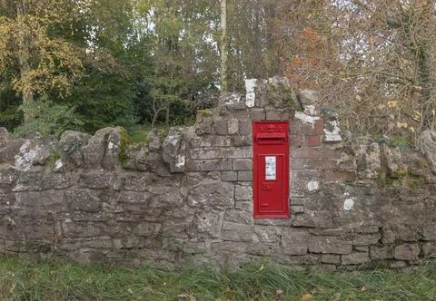 Post box embedded in a jagged brick wall Stock Photos