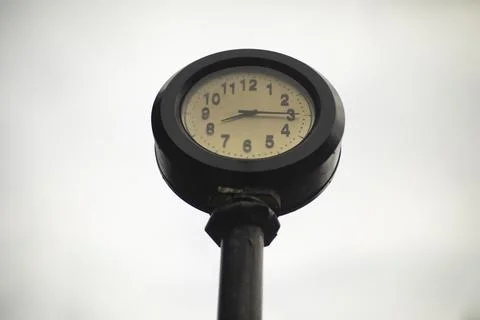 Post clock. Glittering clock against sky. Dial is outside. Stock Photos