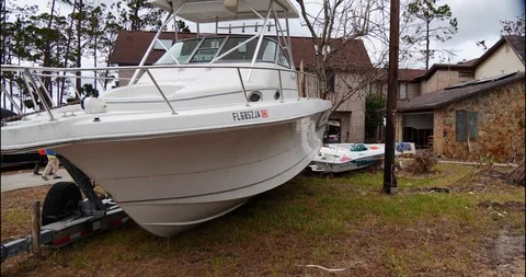Post Hurricane Michael, large boat off trailer, couple walks away, house, debris Stock Footage 98908444