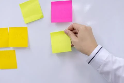 Post-it note with hand on white background Stock Photos