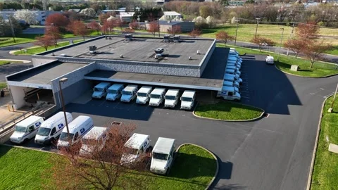Post office distribution building with many USPS trucks for mail delivery. Stock Footage 243345111