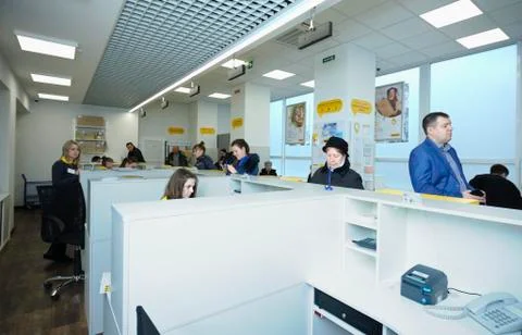 At the post office, reception: postal worker sitting at the desk set with com Fotos Stock