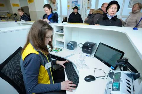 At the post office, reception: postal worker sitting at the desk set with com Fotos Stock