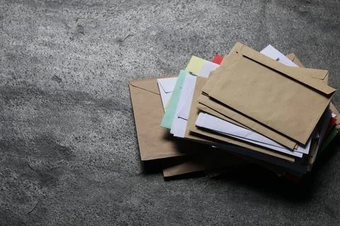 Post office. Stack of different paper envelopes on dark grey table, above v.. 写真素材