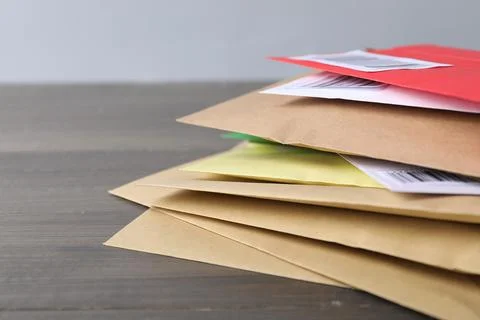 Post office. Stack of different paper envelopes on wooden table, closeup. S.. Foto stock