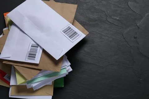 Post office. Stack of different paper envelopes on black table, above view... Foto stock