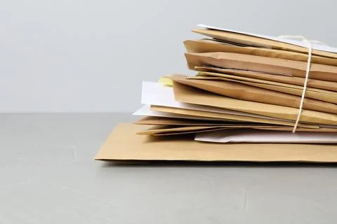 Post office. Stack of different paper envelopes on grey table, closeup. Spa.. 스톡 사진