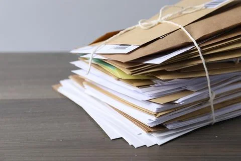 Post office. Stack of different paper envelopes on wooden table, closeup. S.. Foto stock