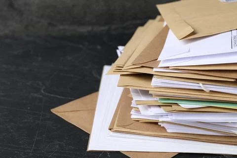 Post office. Stack of different paper envelopes on black table, closeup. Sp.. 스톡 사진
