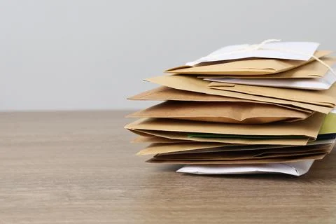 Post office. Stack of different paper envelopes on wooden table, closeup. S.. Foto stock
