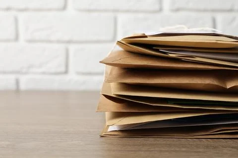 Post office. Stack of different paper envelopes on wooden table, closeup. S.. Foto stock