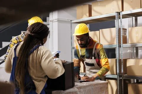Post office warehouse managers checking parcel invoice before delivery Foto stock