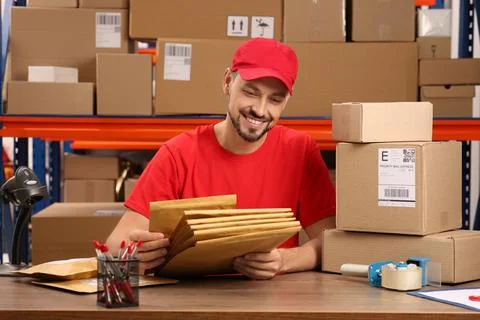 Post office worker with adhesive paper bags at counter indoors 스톡 사진