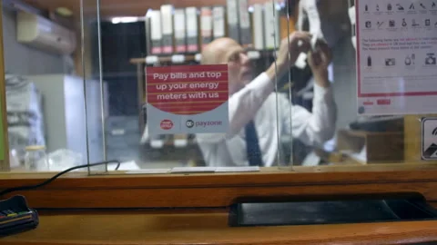 Post office worker labelling a parcel to be shipped by the postal service Stock Footage 172542951