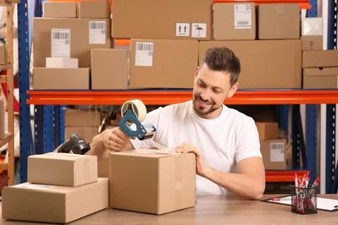 Post office worker packing parcel at counter indoors Stock Photos
