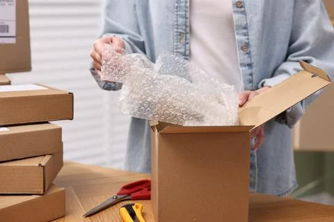 Post office worker packing parcel at wooden table indoors, closeup Stock Photos