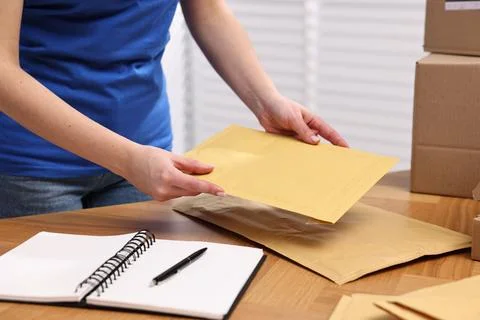 Post office worker packing parcel at wooden table indoors, closeup Stock Photos