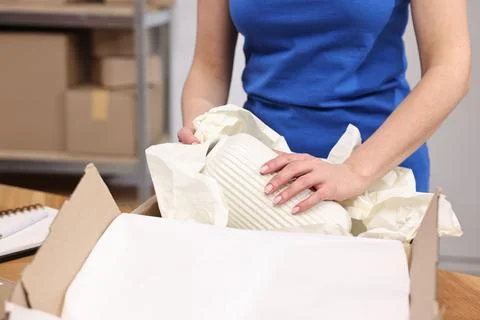 Post office worker packing parcel at table indoors, closeup Stockfoto's