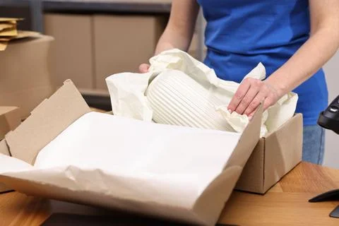 Post office worker packing parcel at wooden table indoors, closeup Stock Photos