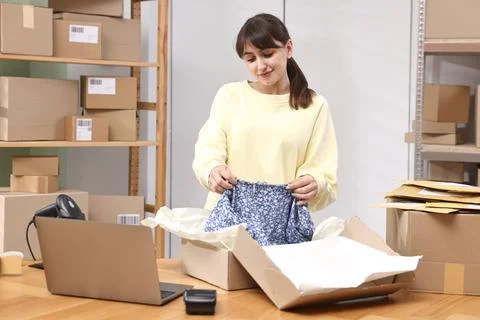 Post office worker packing parcel at wooden table indoors Foto stock