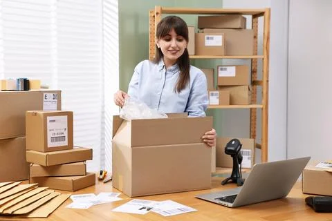 Post office worker packing parcel at wooden table indoors Stock Photos