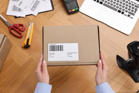 Post office worker packing parcel at wooden table, top view Photos