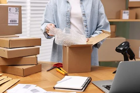 Post office worker packing parcel at wooden table indoors, closeup Stock Photos