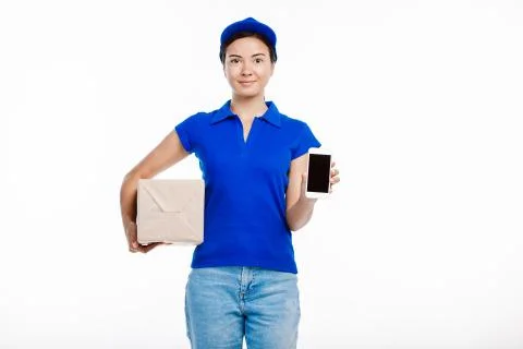Post office worker poses at the camera holding a parcel and a tablet. Stock Photos