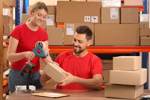 Post office workers packing parcel at counter indoors Stockfoto's