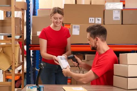 Post office workers with scanner reading parcel barcode indoors Foto stock
