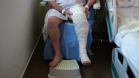Post-op patient doing knee rehab exercises in a hospital chair. Stock Footage 310563651