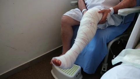 Post-op patient doing knee rehab exercises in a hospital chair. Stock Footage 310563655