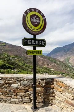 Post at viewing platform overseeing Danba Jiaju Tibetan Village with message in Stock Photos
