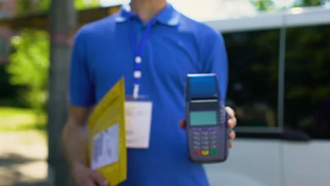 Post worker showing parcel and credit card terminal, payment service client care Stock Footage 91233133