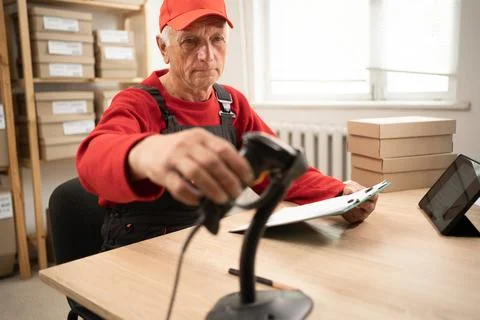 Postal employee scans parcel barcode for tracking and delivery management in  Stock Photos
