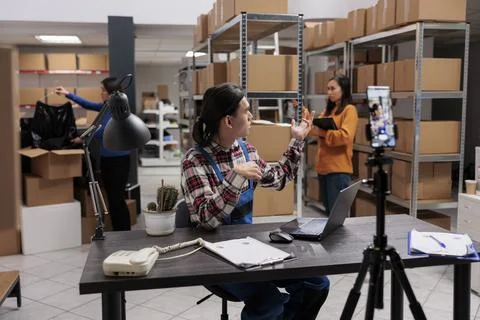 Postal shipment manager streaming parcel shipping operations on smartphone Foto stock