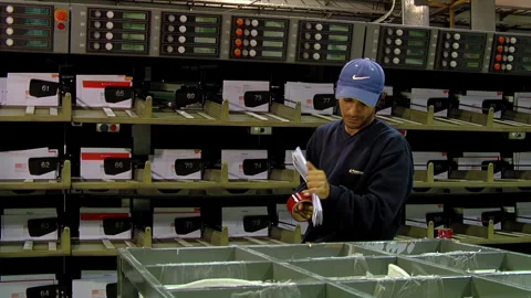 Postal Worker Bundling Letters with Adhesive Tape in Distribution Center - 4K Stock Footage 336685353