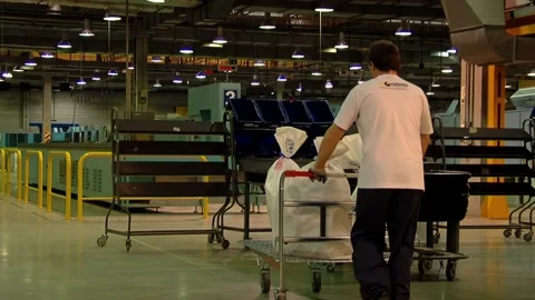 Postal Worker Entering Distribution Center with Mail Cart for Sorting  Stock Footage 154877889