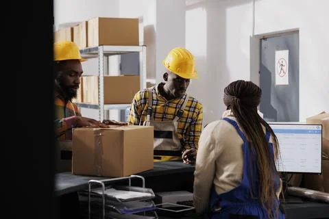 Postal worker examining packed parcel before delivery at checkout Stock Photos