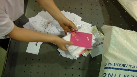 Postal Worker Sorting Letters and Envelopes from Mail Bag on Work Table   Stock Footage 154875991