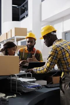 Postal workers checking parcel invoice on laptop and clipboard Foto stock