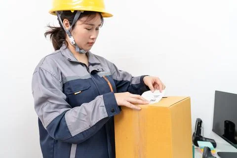 Postal workers handle parcel boxes by attaching barcode stickers. Stock Photos