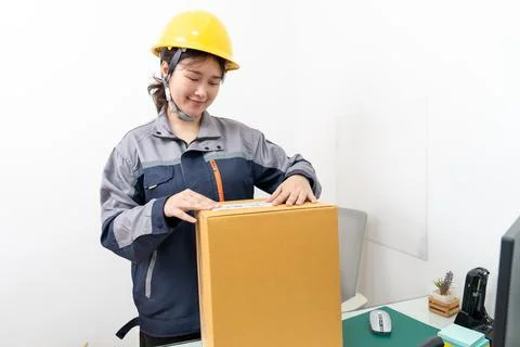 Postal workers handle parcel boxes by attaching barcode stickers. Stock Photos