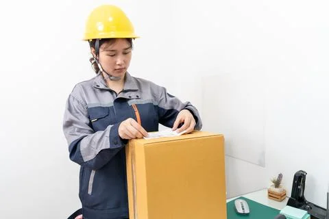 Postal workers handle parcel boxes by attaching barcode stickers. Stock Photos