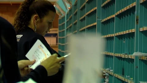 Postal Workers Handling Mail and Placing Letters in Boxes - Close Up Stock Footage 154876463