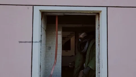 Postapocalypse, man in old torn clothes in masks amid the destroyed building Stock Footage 90529823