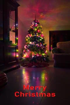 Postcard with a Christmas tree in a window with colored lights with the inscr Foto stock