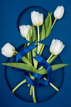 Postcard for The Eighth of March. Five white tulips in number eight. Tied with a Stockfoto's