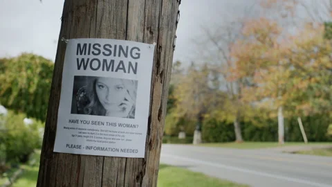 Poster for a missing young woman hangs on a pole near the road Stock Footage 205601582